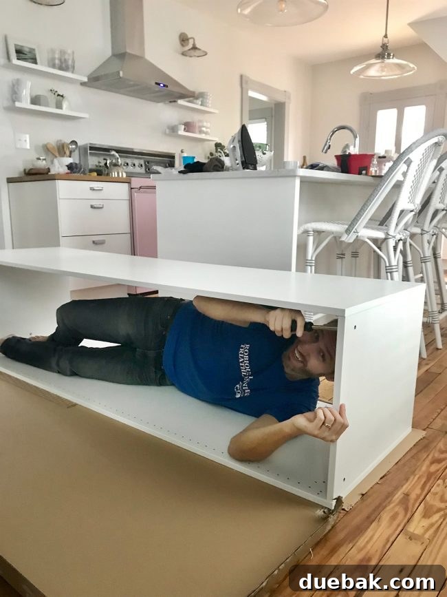 Ikea Cabinet Water Heater Makeover 11 john laying in ikea cabinet during assembly