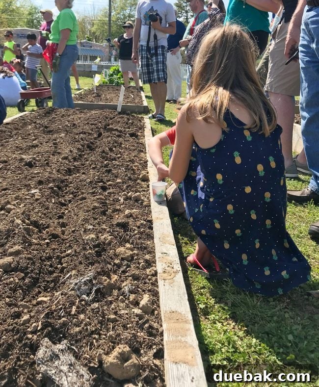 Children participating in the 'Blessing of The Worms' event at a community youth garden