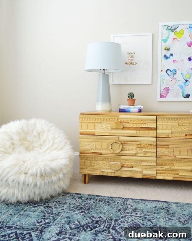 Dresser with a cozy beanbag chair and decorative art in S's bedroom