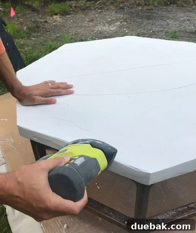 Sanding the first coat of Ardex with a palm sander