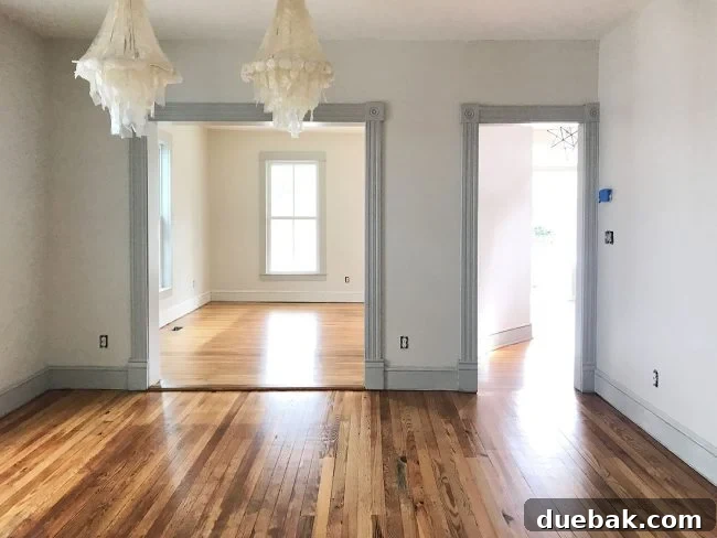 Refinished pine floors in dining room with thermostat near light switch