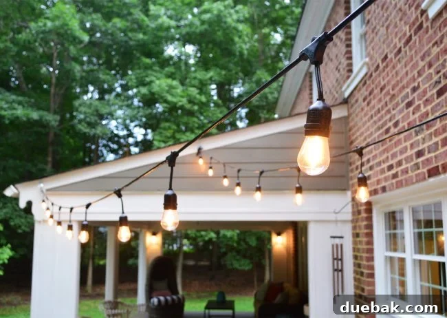 Out With the Deck, In With a Pea Gravel Patio 16 Outdoor string lights suspended above the pea gravel patio, creating a warm evening ambiance.