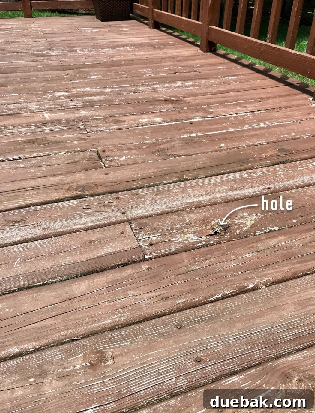 Out With the Deck, In With a Pea Gravel Patio 4 Close-up of the deteriorating wooden deck, showing warped boards and exposed nails.