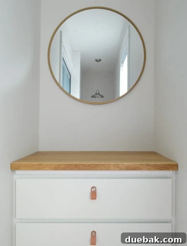 Seamless Malm Dresser Integration 11 Finished IKEA Malm dresser with a butcher block counter and stylish leather pulls, underneath a round gold mirror