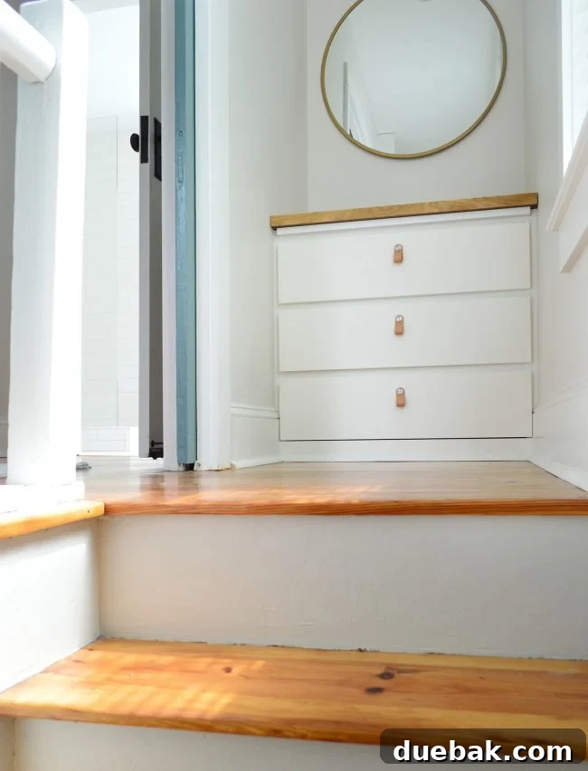 Seamless Malm Dresser Integration 15 Elegant IKEA Malm built-in dresser at the top of the stairs with a decorative mirror, enhancing storage and style