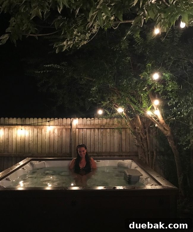 Hot tub glowing at night under garden string lights