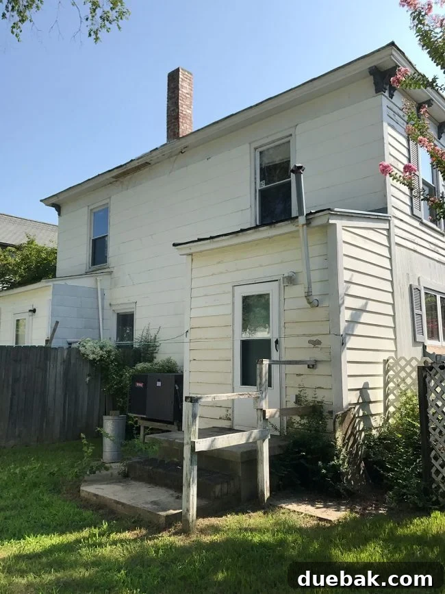 Before image of the duplex's rear exterior, showing its dilapidated state before the significant renovation and expansion.