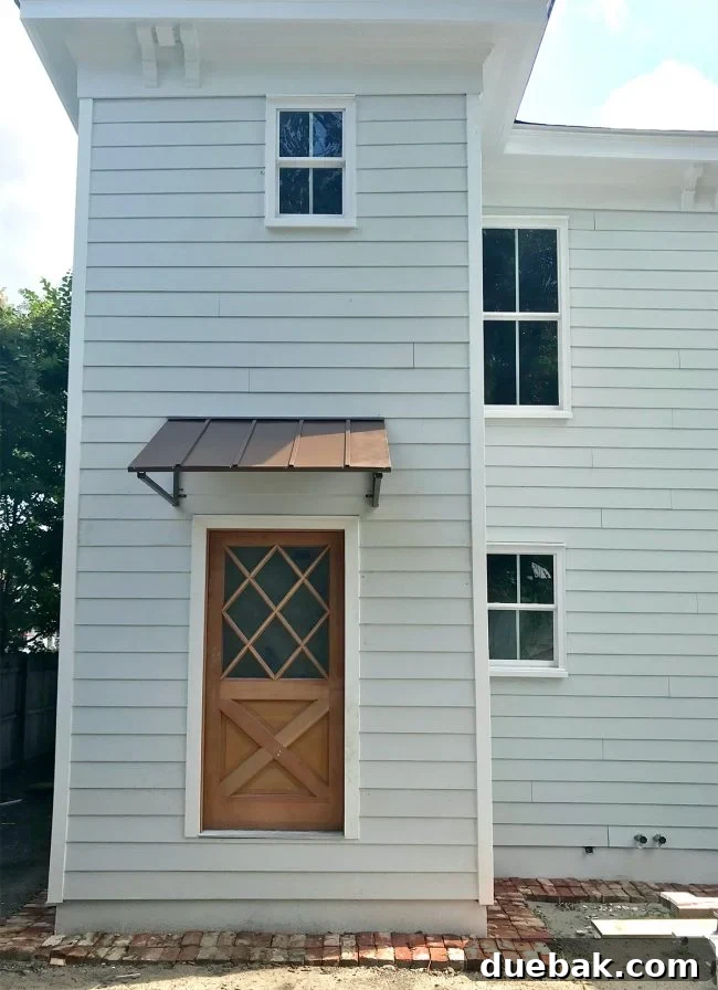 Newly installed metal awnings on the duplex rear, showing optimal height for view and light preservation from inside.