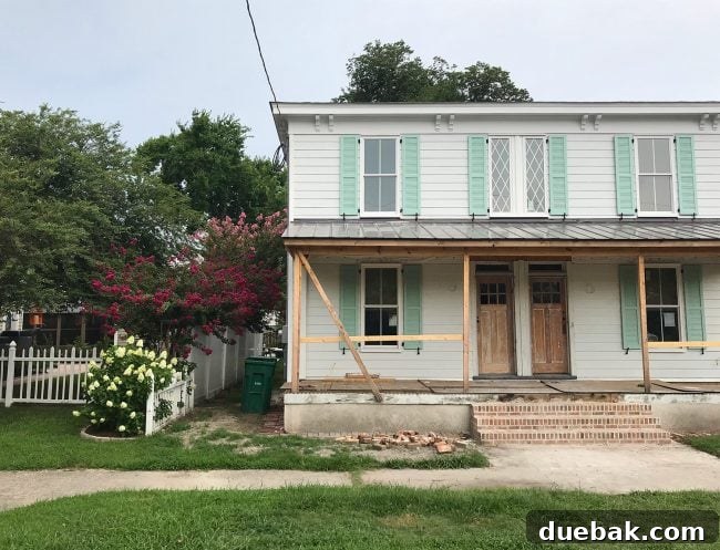 Newly installed siding, windows, and shutters on the duplex exterior, showcasing significant progress and enhanced curb appeal.