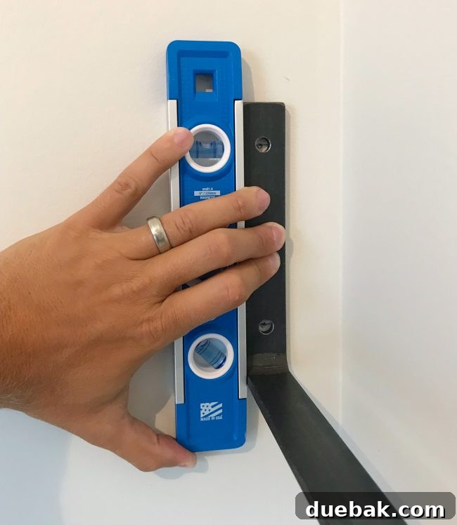 Leveling an individual decorative iron shelf bracket before final attachment
