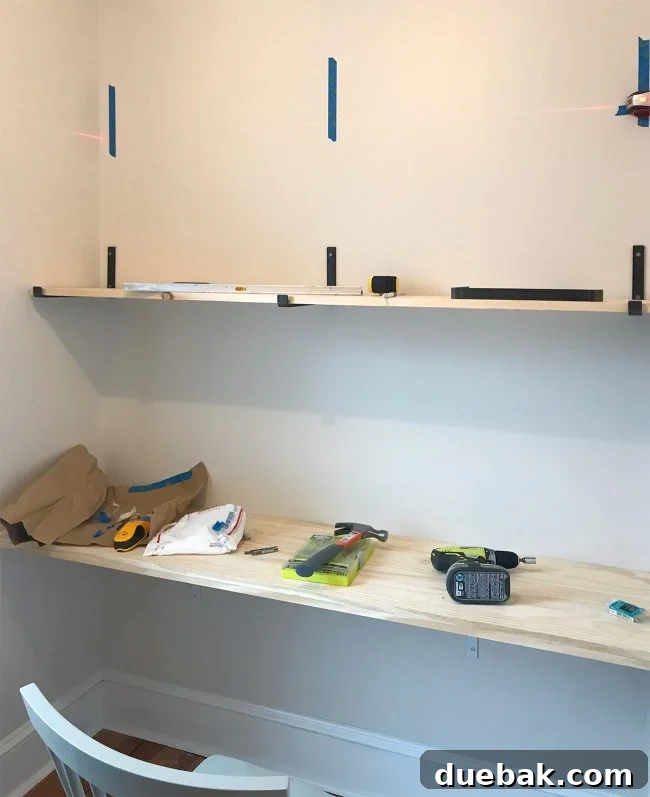 Second shelf being installed above the first with decorative brackets