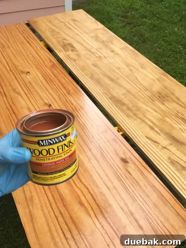 Applying second coat of Minwax Colonial Maple stain to wood