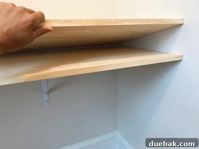 Two pine planks laid on desk brackets for DIY desktop
