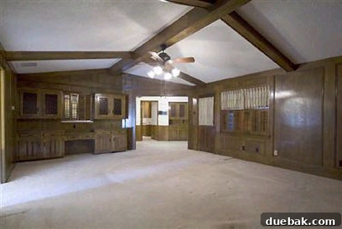 Dated living area before renovation, looking towards kitchen with old finishes