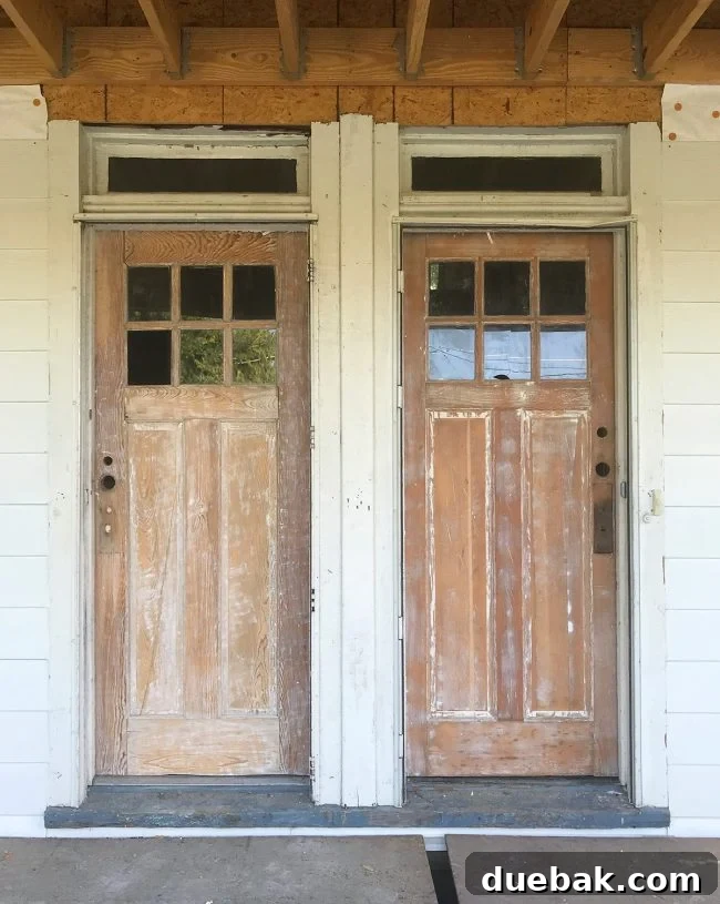 Close-up of duplex front doors with misaligned and numerous old holes where previous hardware was installed, demonstrating a common renovation challenge.
