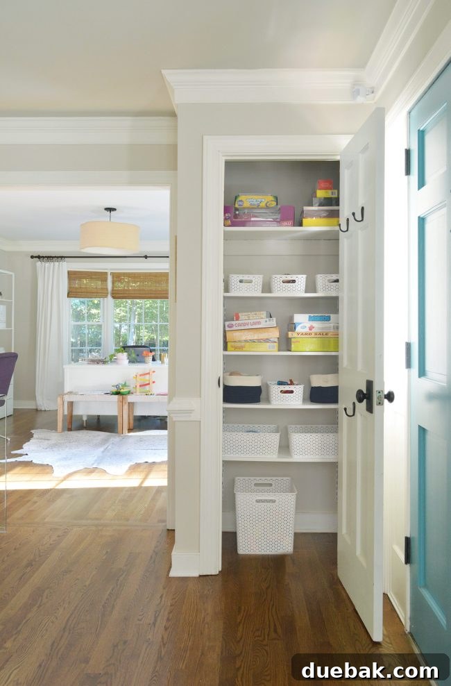 A neutral foyer with a kids' game closet, showing a motion detector prominently placed on the crown molding in the corner, hinting at the embarrassing story.