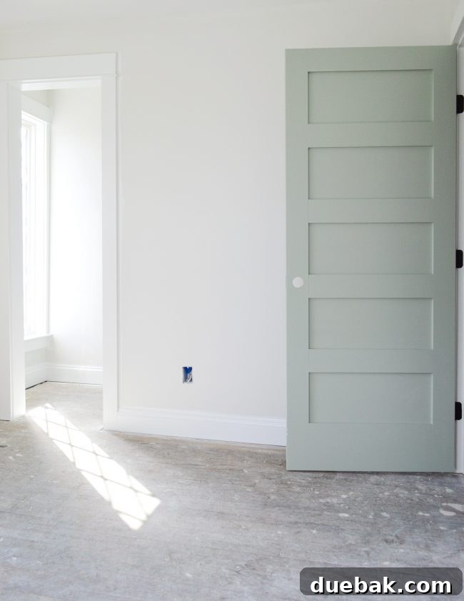 Shadows from diamond-paned windows reflecting on the floor near an Oyster Bay painted door