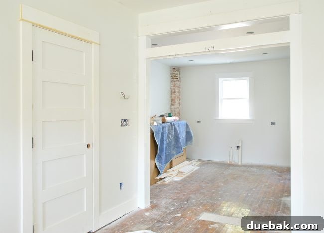 Interior view showing new five-paneled doors, transom window, and exposed brick chimney