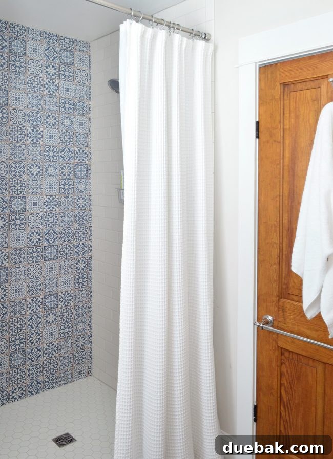 Our Beach House Makeover: Upstairs Edition 19 Hall bathroom with blue patterned tile and original wooden door with unique knob