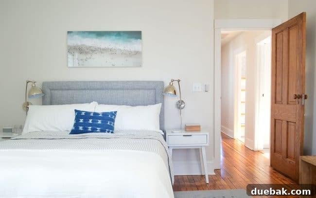 Our Beach House Makeover: Upstairs Edition 21 Beach house back bedroom after renovation, showing refinished floors and original wooden door