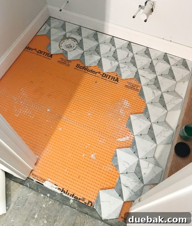 Tiling progress shot, showing hex tiles laid out on the floor before thinset is applied.