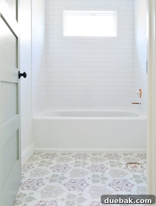 Completed hall bathroom with patterned hex floor tile, white walls, and a drop-in tub.