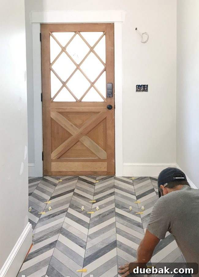 Mudroom floor mid-tiling, featuring large format chevron tiles and LASH spacers.