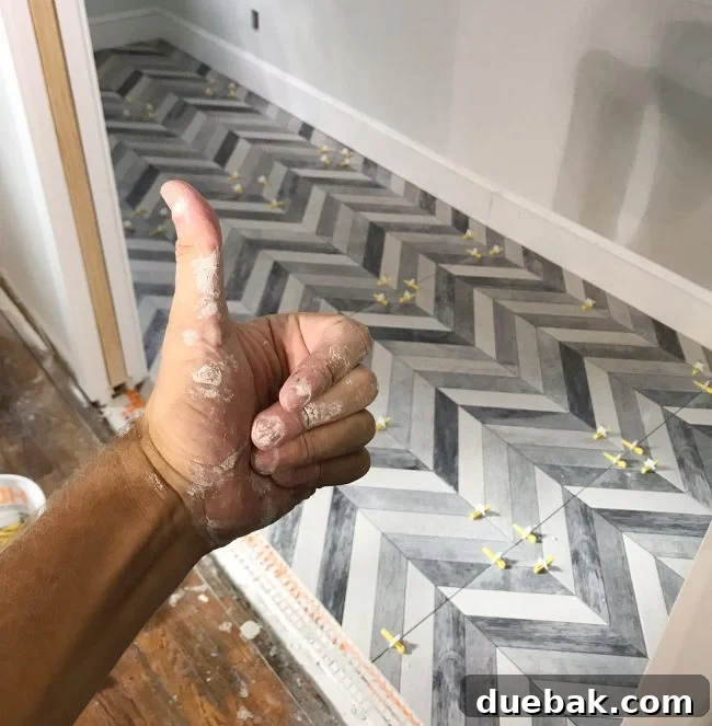View of a large mudroom floor with chevron pattern tiles.