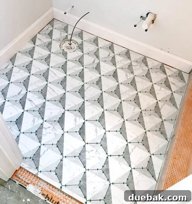 Close-up of a perfectly cut tile around a toilet flange on a bathroom floor.