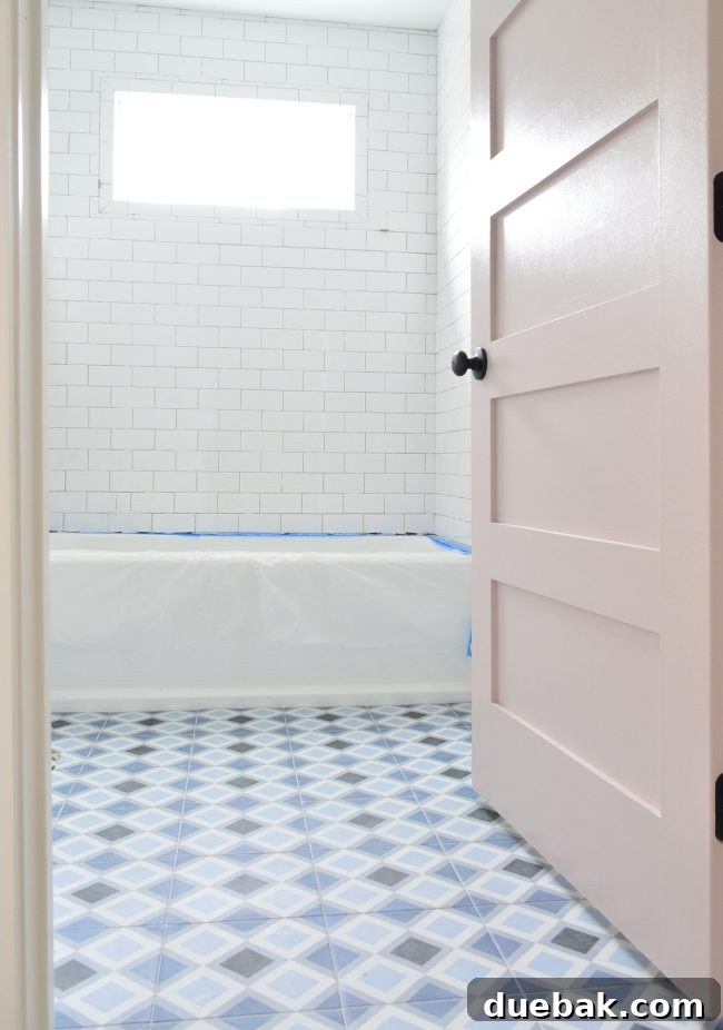 Completed bathroom with patterned floor tile, white walls, and a drop-in tub.