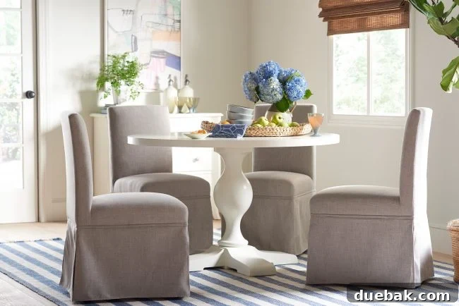 Skirted Upholstered Dining Chair and Pedestal Table in a sophisticated dining area
