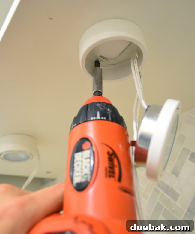 Elevate Your Kitchen Design with Under-Cabinet Lighting 5 Multiple under cabinet spotlights securely mounted to the underside of a cabinet, with wiring prepared for connection.