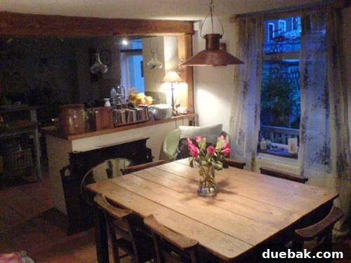 Rustic Country Cottage Dining Room Charming country cottage dining room featuring a rustic wooden plank table and vintage school chairs, showcasing a blend of repurposed and unique decor.