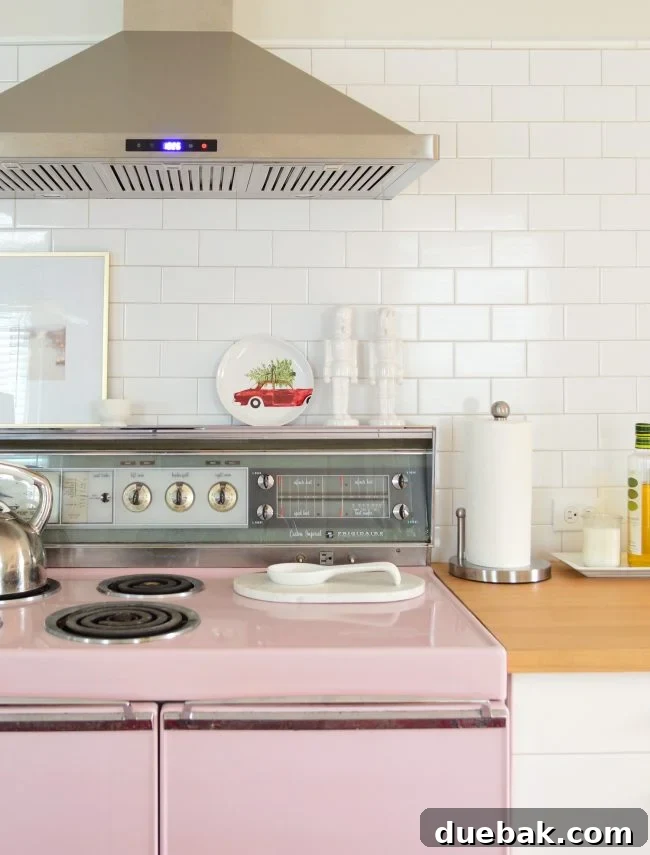 Double the Sparkle: Holiday Decorating at Home and the Beach 19 A pink stove area decorated with a holiday plate and two white ceramic nutcrackers.