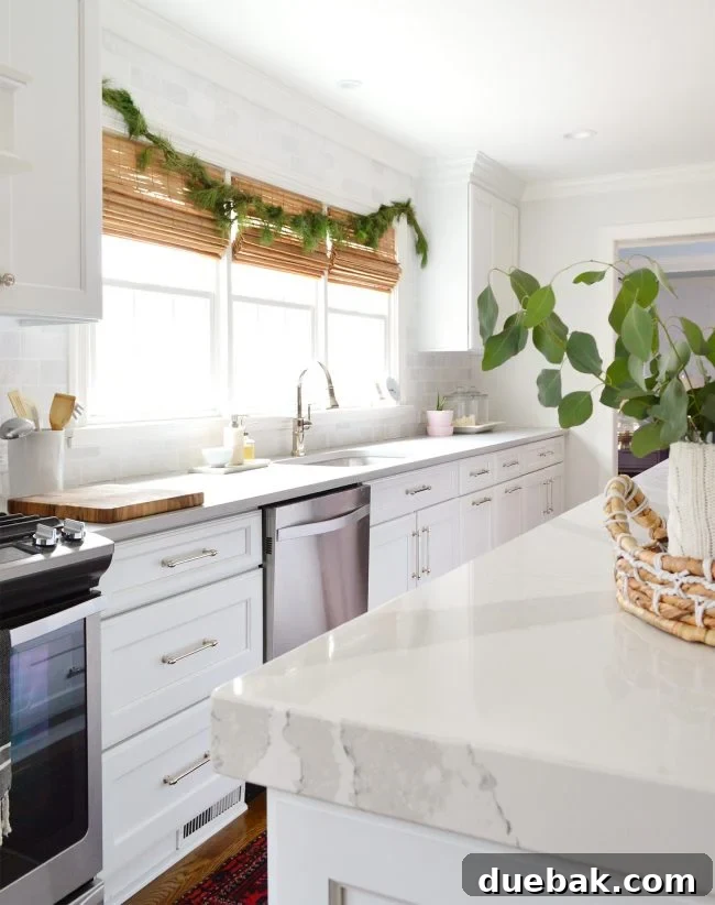 Double the Sparkle: Holiday Decorating at Home and the Beach 4 A kitchen window decorated with a fresh evergreen garland.