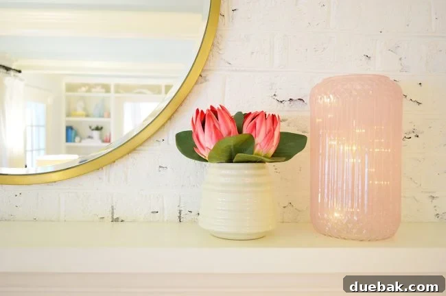 Double the Sparkle: Holiday Decorating at Home and the Beach 7 Mantel decor featuring a faux flower pot and a pink vase with battery lights.