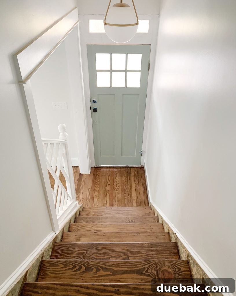 Reviving Oak and Pine Floors 20 Updated view looking down the refinished stairs towards the front door, showcasing significant progress.