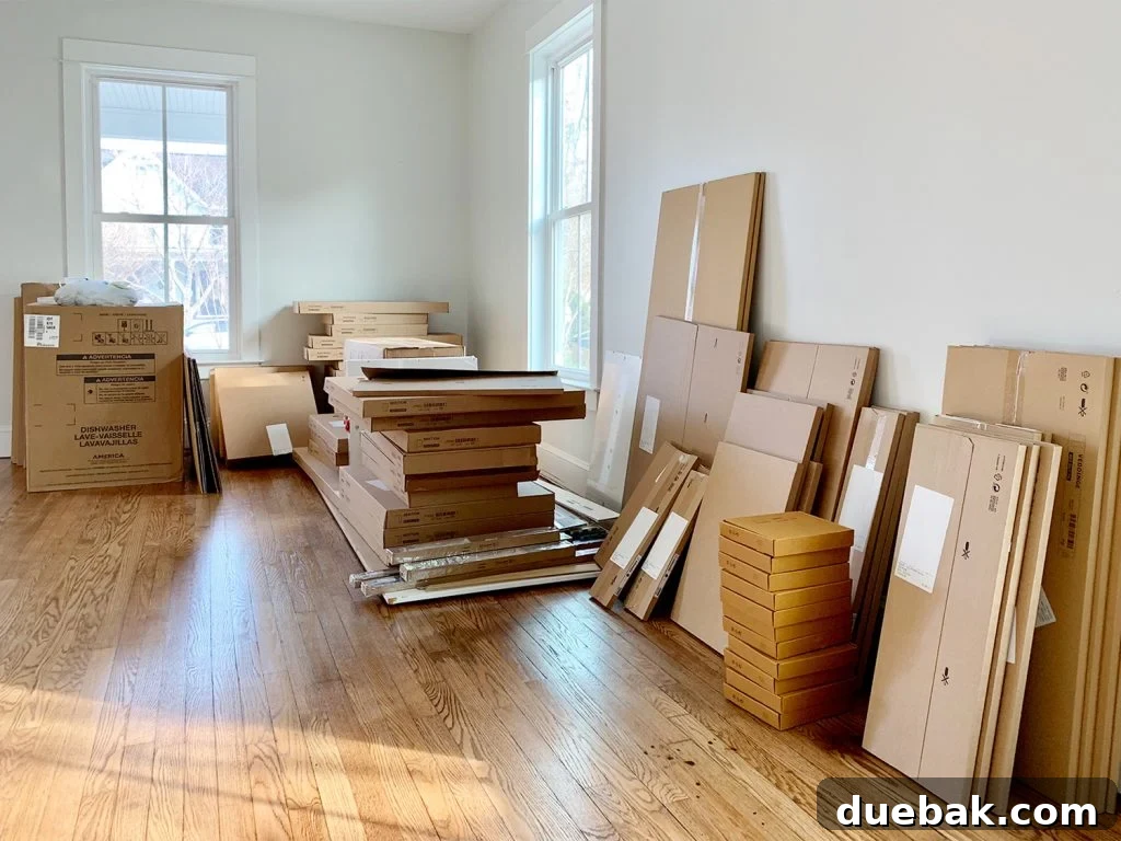 A room completely filled with stacks of numerous flat-pack Ikea kitchen boxes, signifying a large installation project.