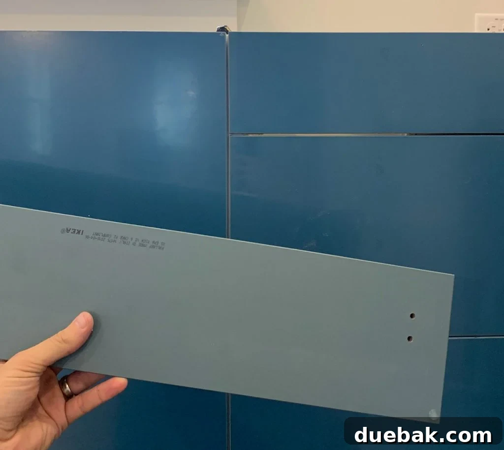 Close-up of duplex kitchen cabinet showing true blue-green-gray color underneath protective film.