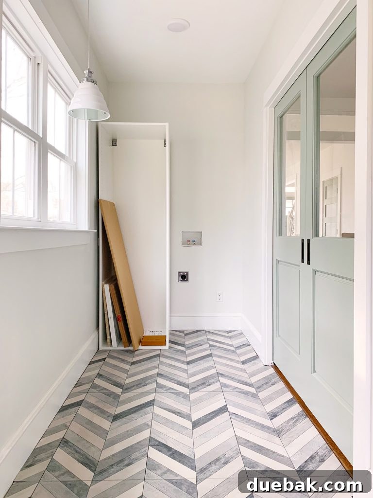 Right side duplex mudroom/laundry room with pocket doors and floor tile.