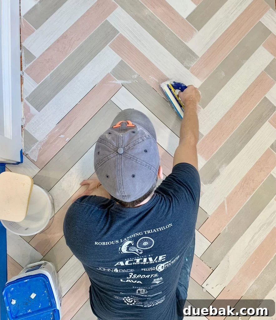Finding Your Best Grout: Tips for Perfect Color Selection 2 John grouting a colorful herringbone mudroom floor with mapei grout