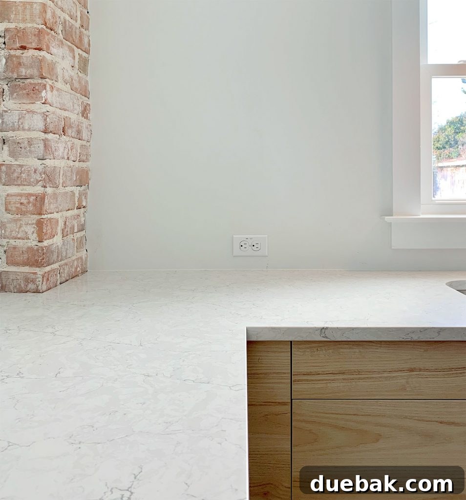 Silestone Pearl Jasmine Quartz counters with wood cabinets and brick chimney