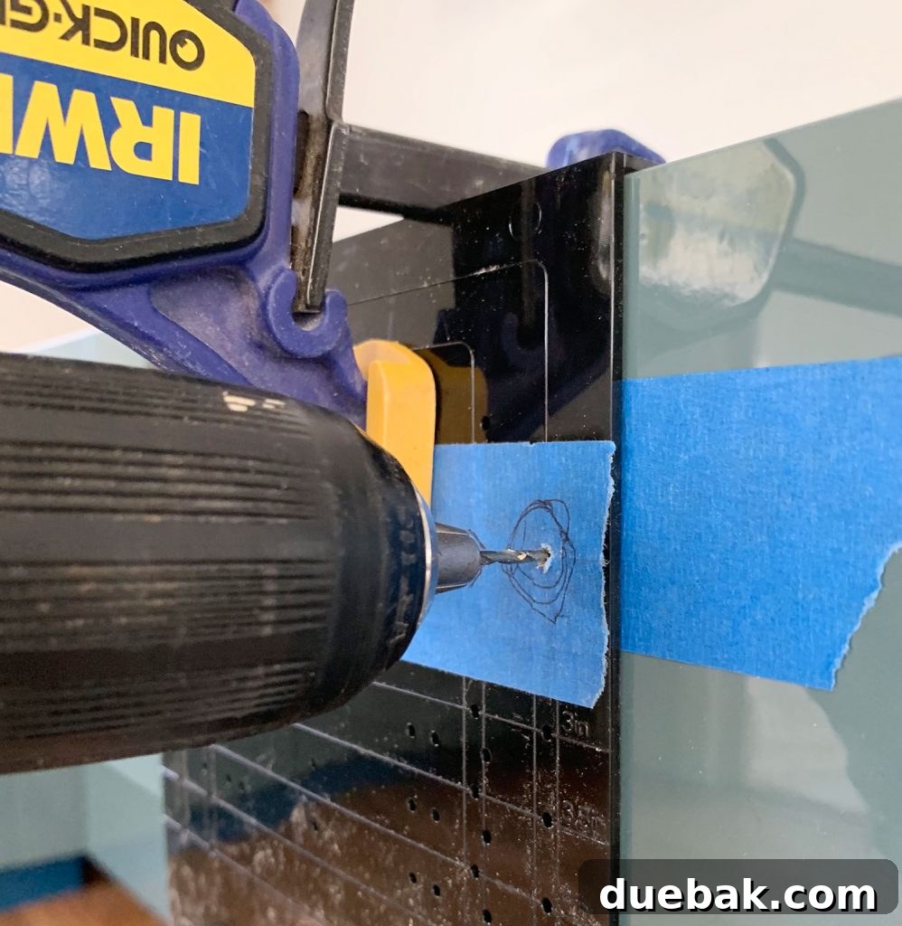 Drilling Pilot Hole Through Hardware Template Clamped To Drawer Front with a small drill bit.