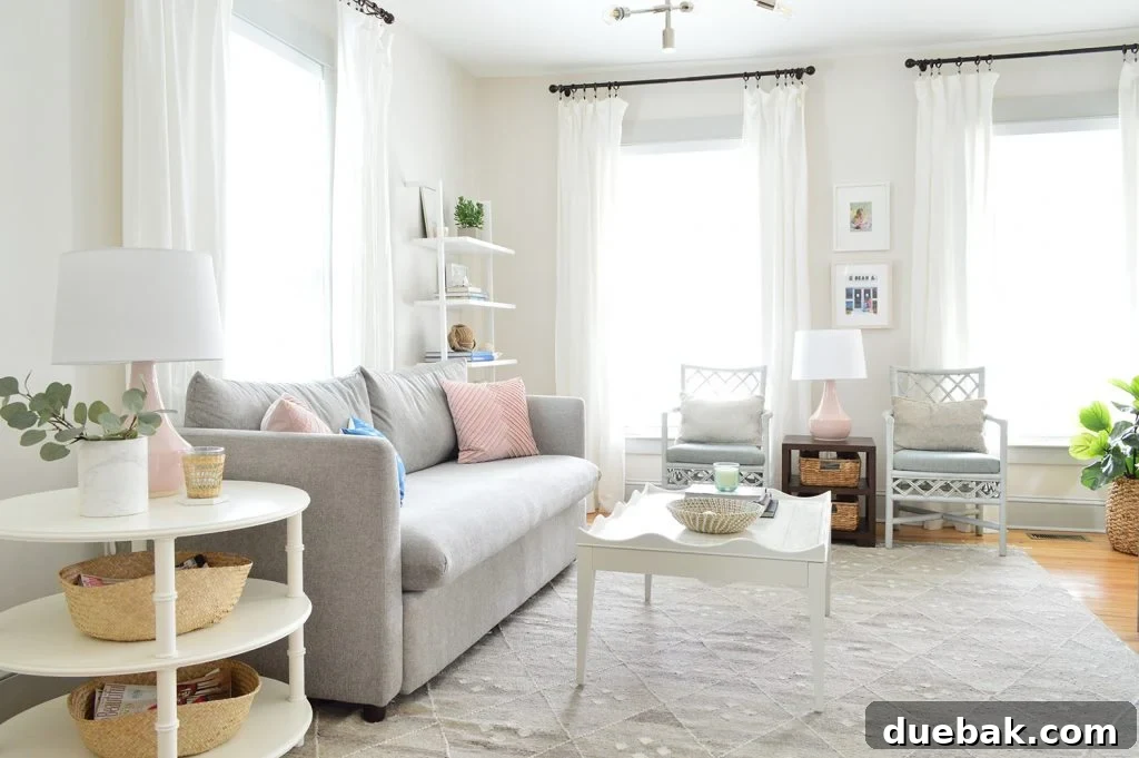 Bright and neutral beach house living room featuring a gray performance fabric sofa, white heron walls, and modern coastal decor.