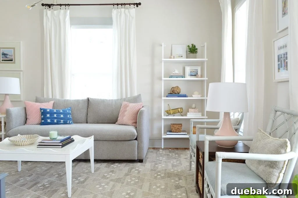 White Heron walls in the beach house living room with a gray sofa and a tall bookcase, showcasing the updated light and airy aesthetic.