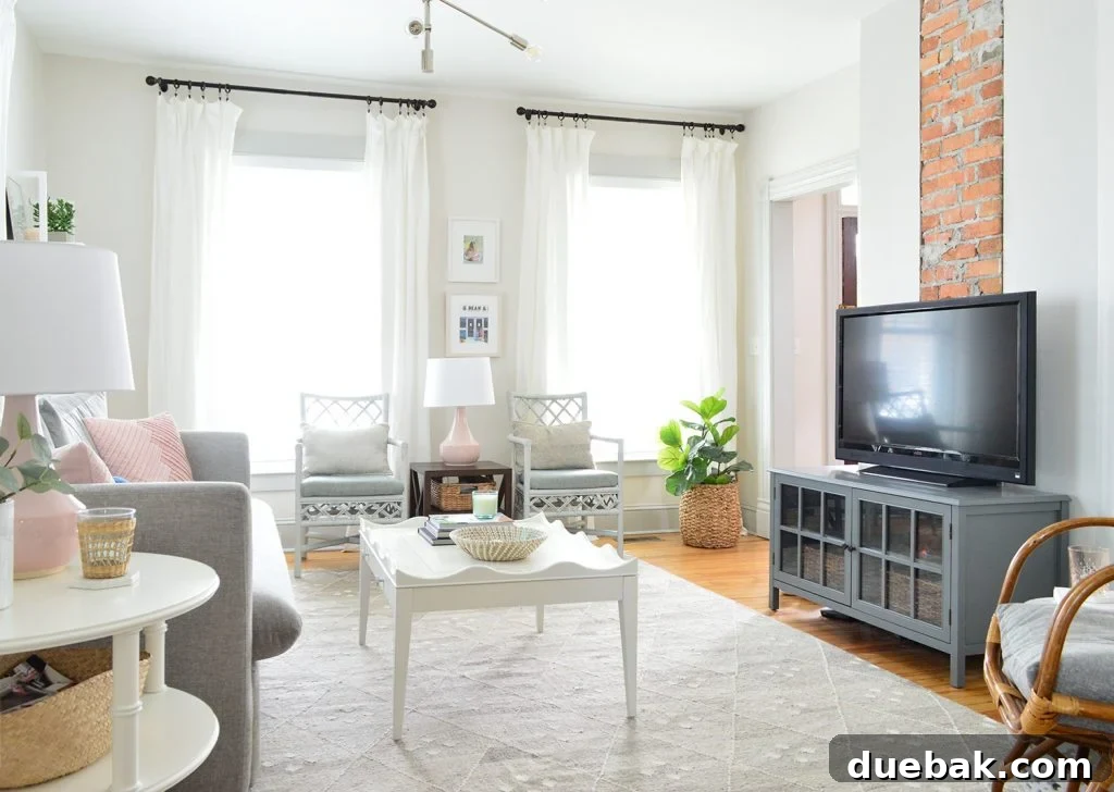 TV in a gray neutral bright living room against an exposed brick chimney, showcasing the current media setup.