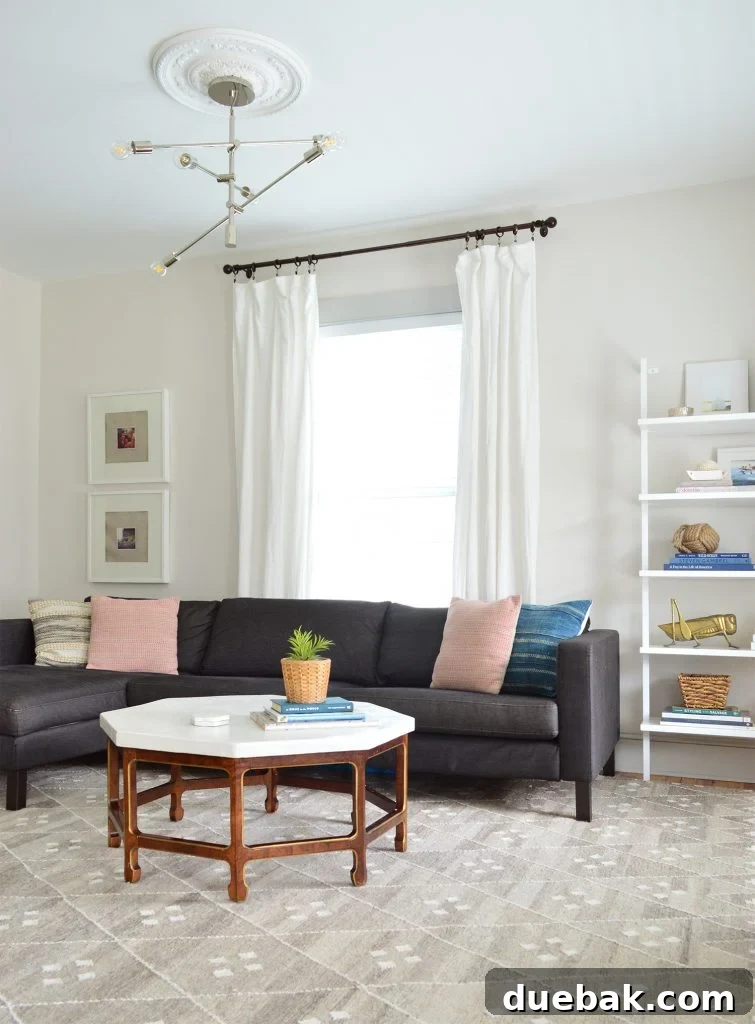 Neutral living room featuring a dark charcoal Ikea sectional before the transformation, highlighting its size and previous layout.