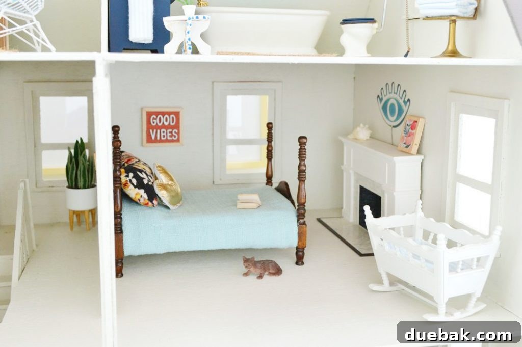 Another dollhouse bedroom with a fireplace, a miniature cat, and unique DIY wall art.