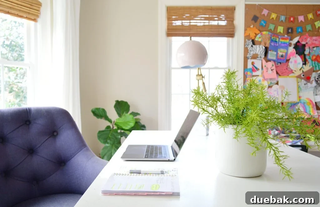 White home office desk with faux greenery in planter