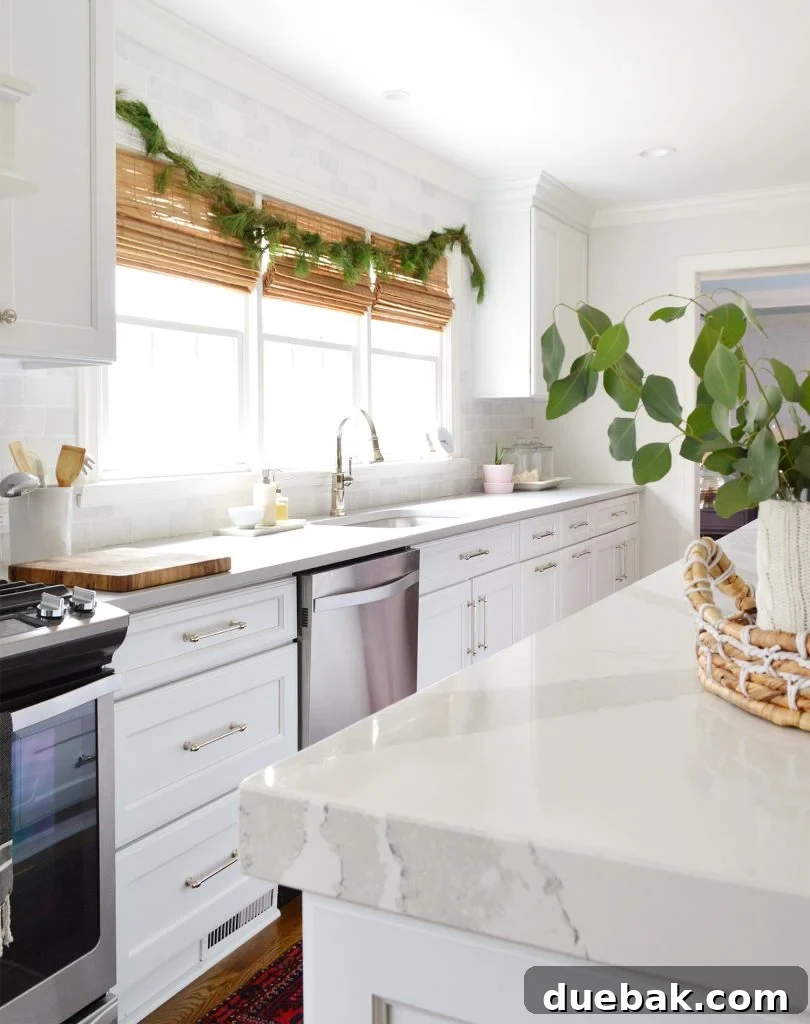 Christmas decor in a kitchen with fresh garland over the sink and eucalyptus